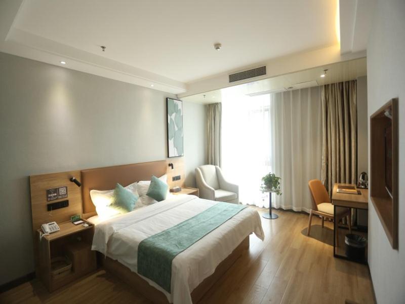 安庆格林豪泰安庆市迎宾东路高铁站客运中心酒店的酒店客房设有一张大床和一张书桌。