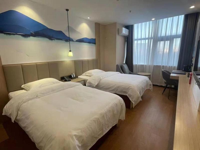 武清格菲天津武清区雍阳西道佛罗伦萨小镇酒店的酒店客房配有两张床和一张书桌