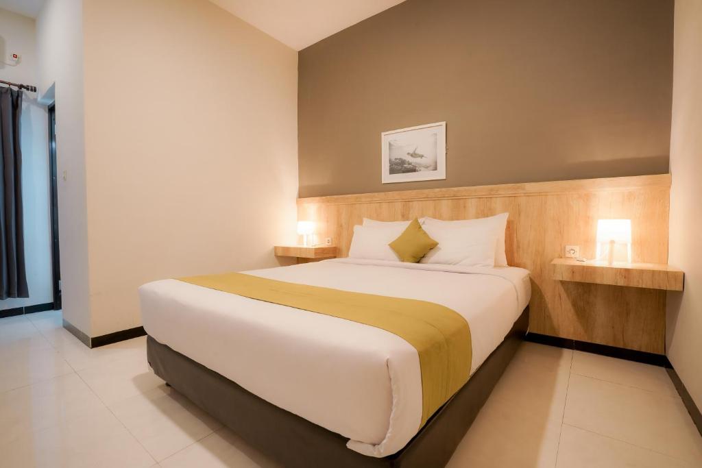 纳闽巴霍El Ora Hotel & Eatery Labuan Bajo的一间卧室配有一张带2个床头柜的大床