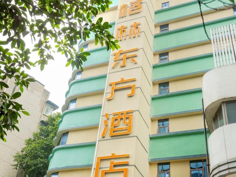 重庆格林东方重庆解放碑儿童医院酒店的一边写着橙色的建筑