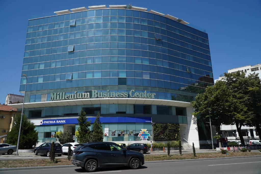 康斯坦察Millennium Hub & Hotel的停在玻璃楼前的汽车