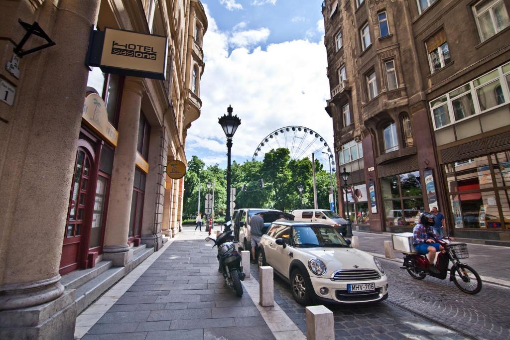 布达佩斯SasOne Rooms的停在建筑物旁的街道上的小型汽车