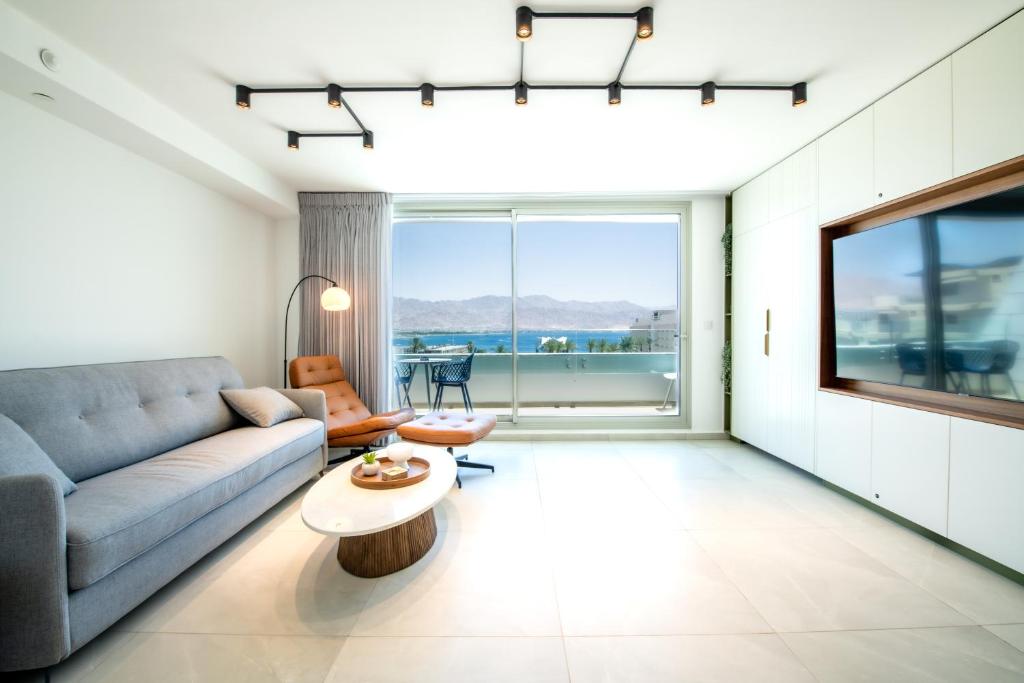 埃拉特Beach Side- Ceasar Luxury Amazing Pool Eilat的客厅配有沙发和桌子