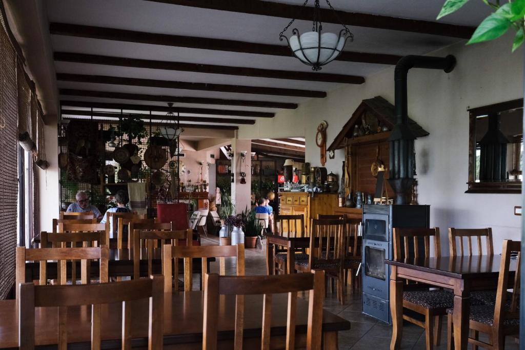 BurreliHotel Vila Bruci的餐厅配有木桌和椅子,背景人员