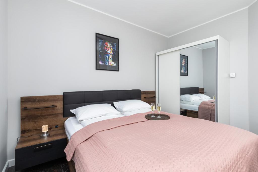 贡斯基Apartamenty Nadbrzeżna 250 m do Plaży by Renters的一间卧室配有一张带粉色毯子的大床