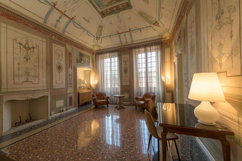 加维Palazzo Sertorio Suites的客房拥有天花板,墙上挂有绘画作品