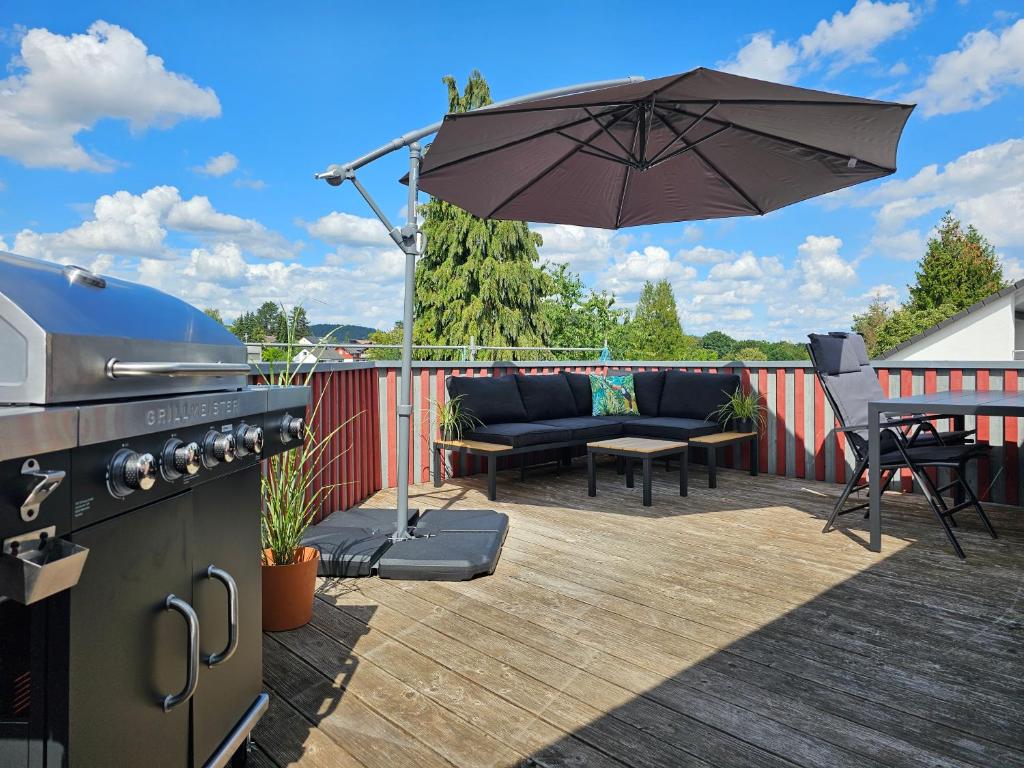 兰河畔马尔堡Tucan - Rooftop Terrace with View, BBQ, PS4+Stream的露台上设有烧烤架和遮阳伞