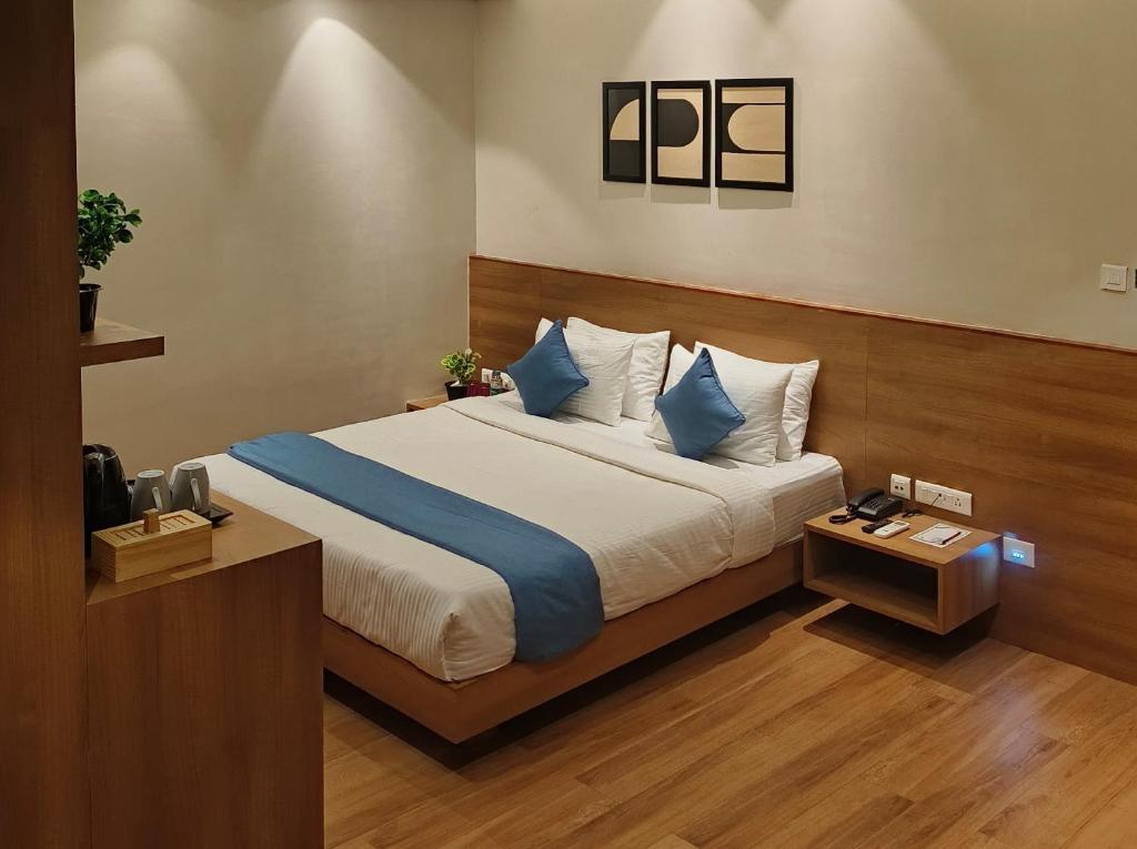 迪布鲁加尔CENTRAL INN的一间卧室配有一张带蓝色和白色枕头的床