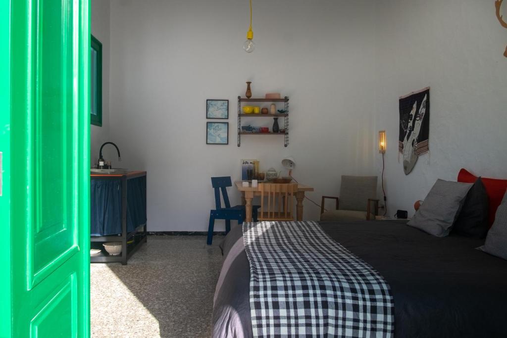 特吉塞Hektor的一间卧室配有一张床、一张桌子和一扇绿门