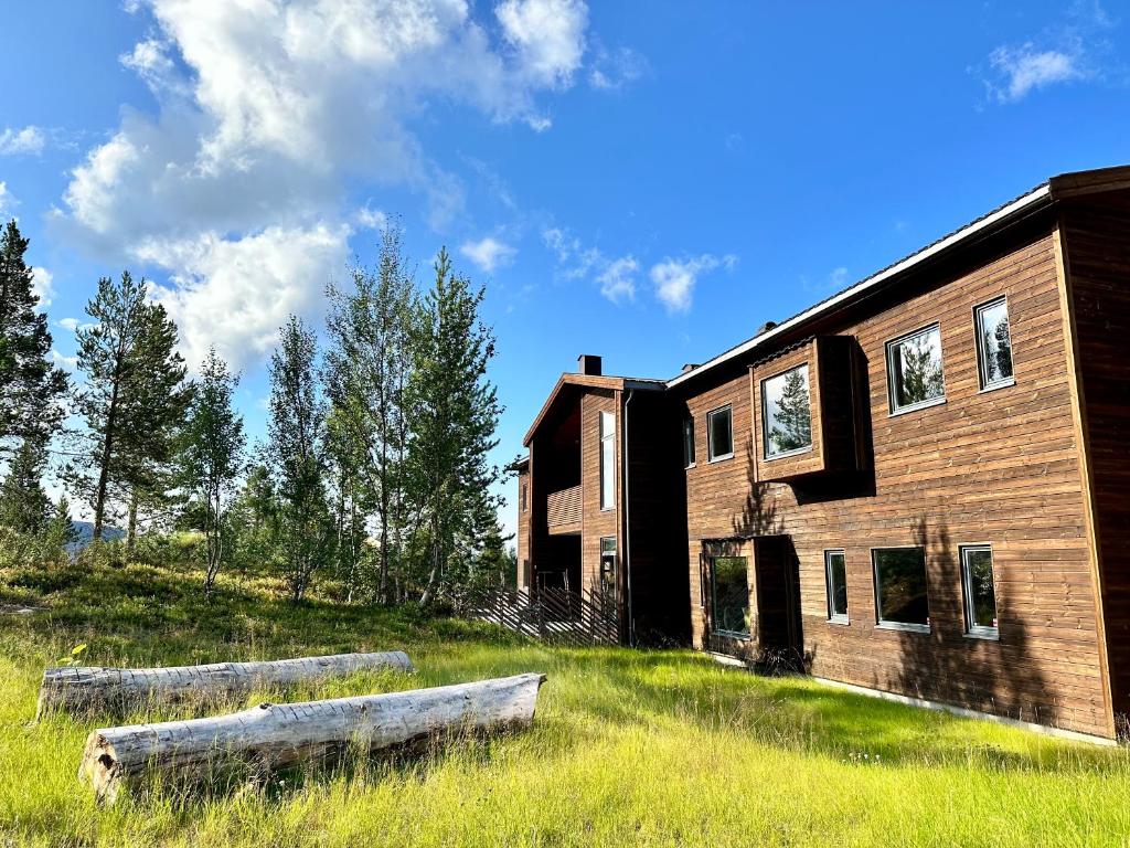 阿尔塔Bjørnfjell Mountain Lodge的旁边草丛中有两个木头的建筑