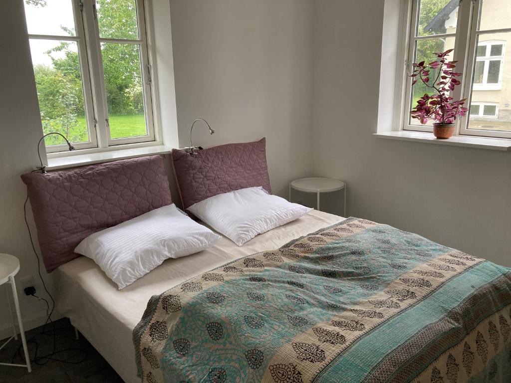 GræstedØrbakke的卧室内的一张床位,设有两个窗户