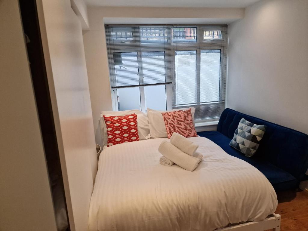 伦敦Lovely 1-Bed Apartment in London的卧室配有带枕头的床铺和窗户。