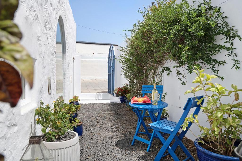 马赫El Piccolo的蓝色的桌子和椅子,位于一个享有海景的庭院