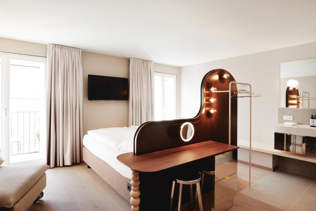 萨尔茨堡Boutique Hotel das Salz的一间卧室配有一张床和一张书桌
