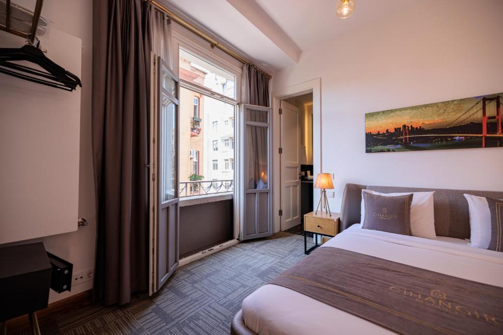 伊斯坦布尔Cihangir Residences的一间卧室设有一张床和一个大窗户