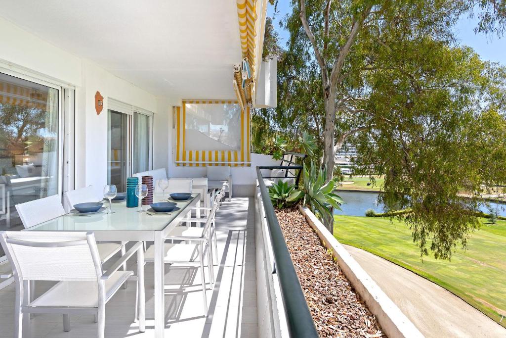 马贝拉Genteel Home Guadalmina Golf的一个带桌椅的庭院和一个游泳池