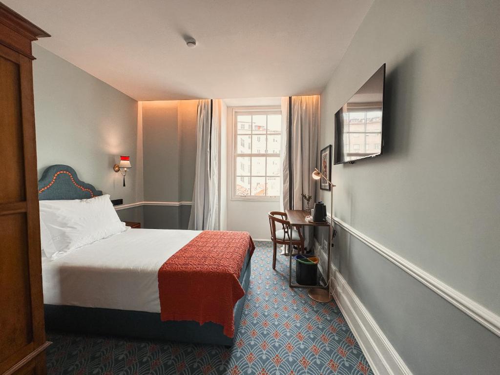波尔图GRANDE HOTEL PARIS by STAY HOTELS的酒店客房设有床和窗户。