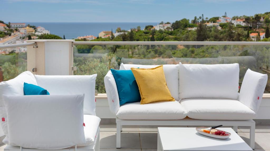 卡武埃鲁Casa Sol 9 by Sevencollection的阳台上配有白色沙发和两把椅子
