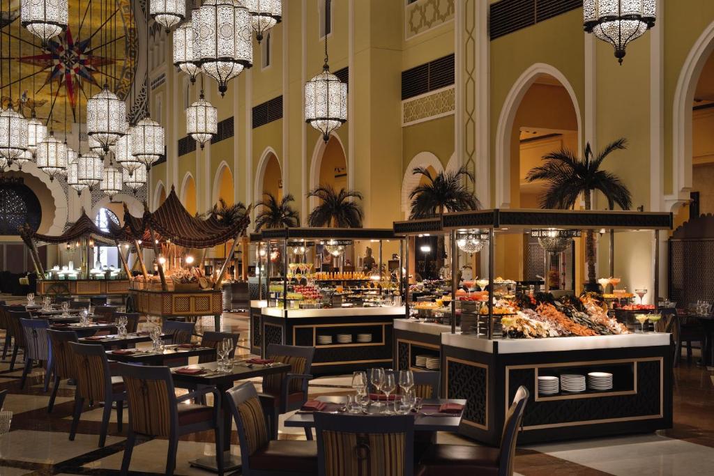 迪拜Oaks Ibn Battuta Gate Dubai的有桌椅和吊灯的餐厅