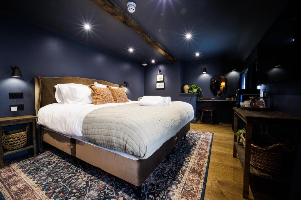 克努斯福德The Silk Rooms, at The Freemasons Inn的一间蓝色客房内配有一张大床的卧室