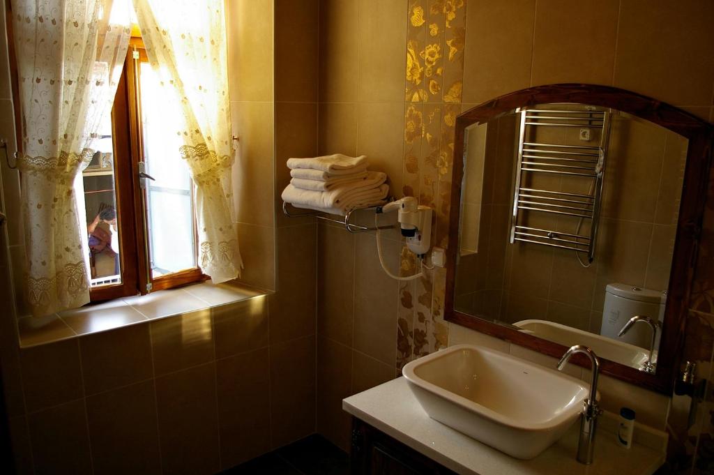 贝尔加马赫拉酒店的一间带水槽和镜子的浴室以及窗户。