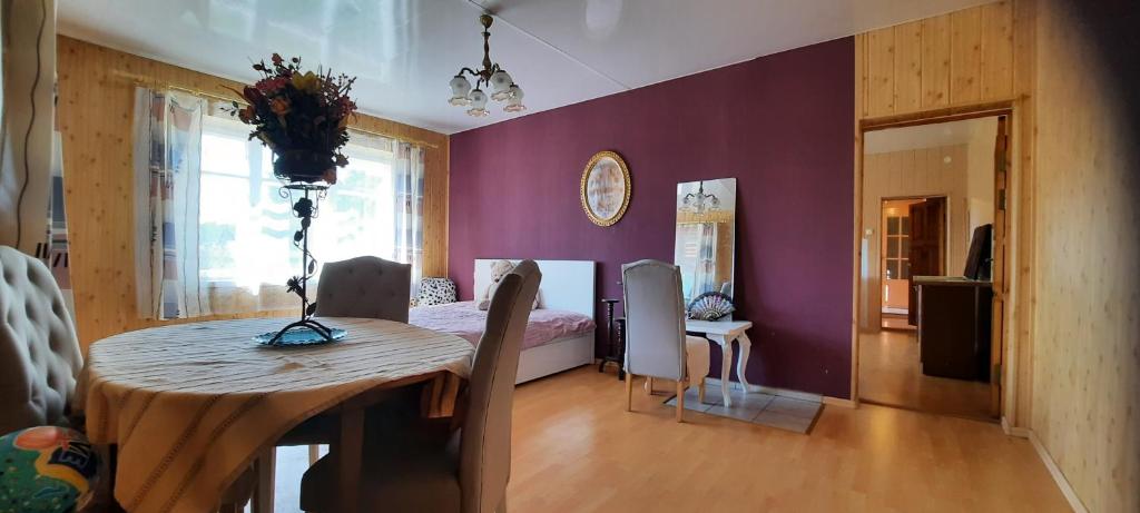 ToliejaiNakvynė keliaujantiems的一间设有一张桌子和紫色墙壁的用餐室