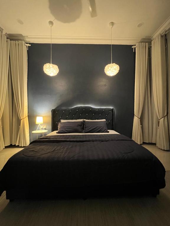 巴西富地Majestic Homestay - Pasir Puteh的一间卧室配有一张带两个灯的黑色床