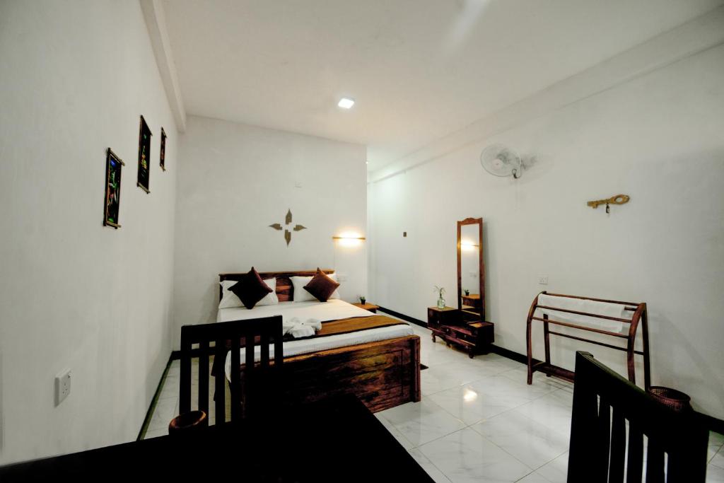 丹不拉Dambulla Kings Inn的一间卧室配有一张床和镜子