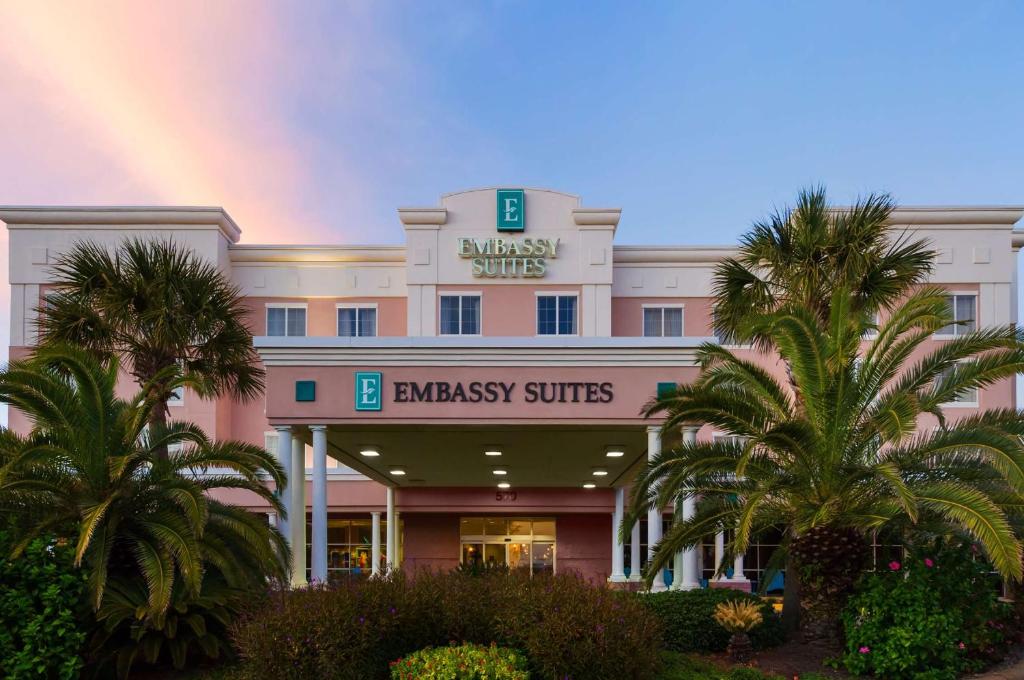 德斯坦Embassy Suites by Hilton Destin Miramar Beach的一座白色的大建筑,天空中有一个彩虹