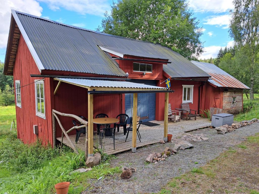 Guesthouse Nature Trails Sweden的红色小屋 - 带甲板和桌子