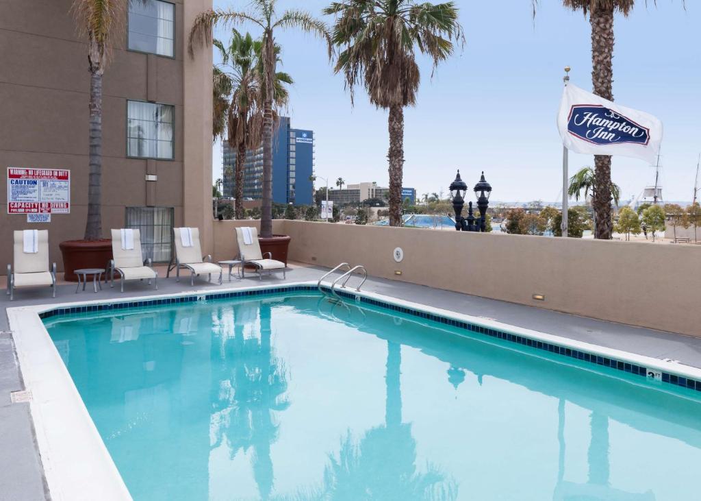 圣地亚哥圣地亚哥市区汉普顿酒店的一个带椅子和棕榈树的大型游泳池