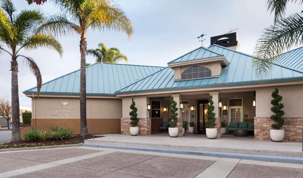 圣何塞圣何塞机场 - 硅谷希尔顿惠庭套房酒店的一座拥有棕榈树的蓝色屋顶建筑