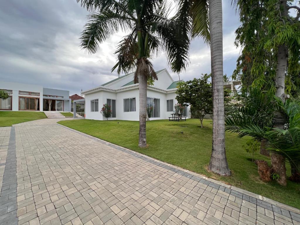 达累斯萨拉姆Datela Home - 3Bed Villa near Ununio Beach Kunduchi的棕榈树房屋和砖车道