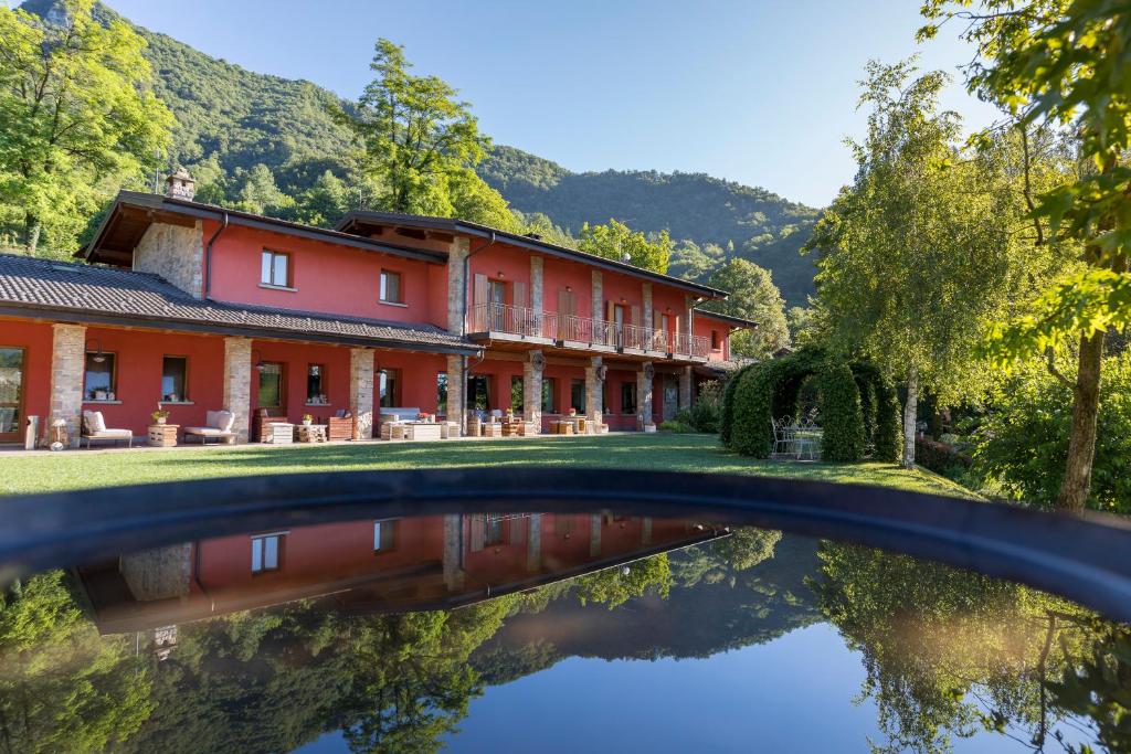 ValseccaAgriturismo Scuderia della Valle的水中反射的红色建筑