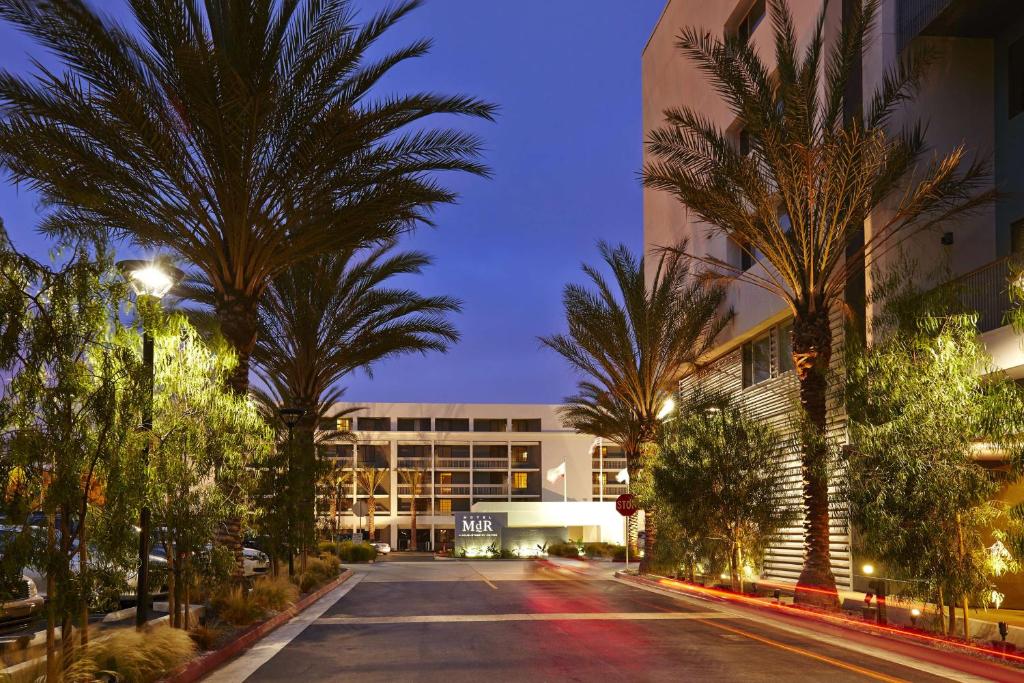 洛杉矶MDR玛丽安德尔湾希尔顿逸林酒店的一座空荡荡荡的街道,在一座建筑前有棕榈树