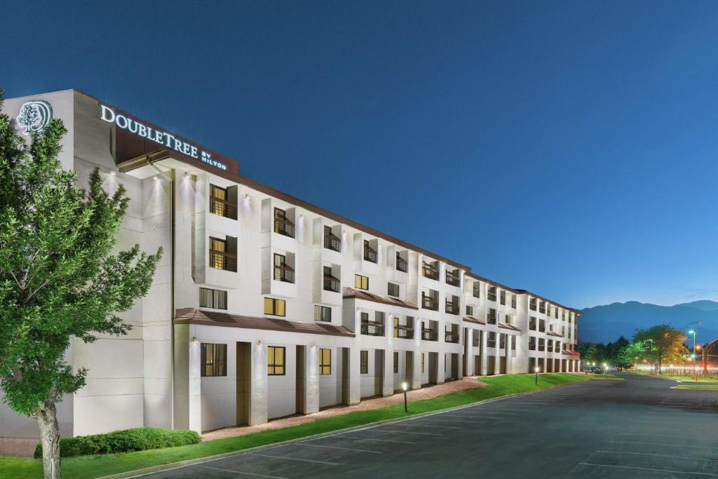 科罗拉多斯普林斯希尔顿逸林科罗拉多温泉酒店的白色的建筑,旁边标有标志