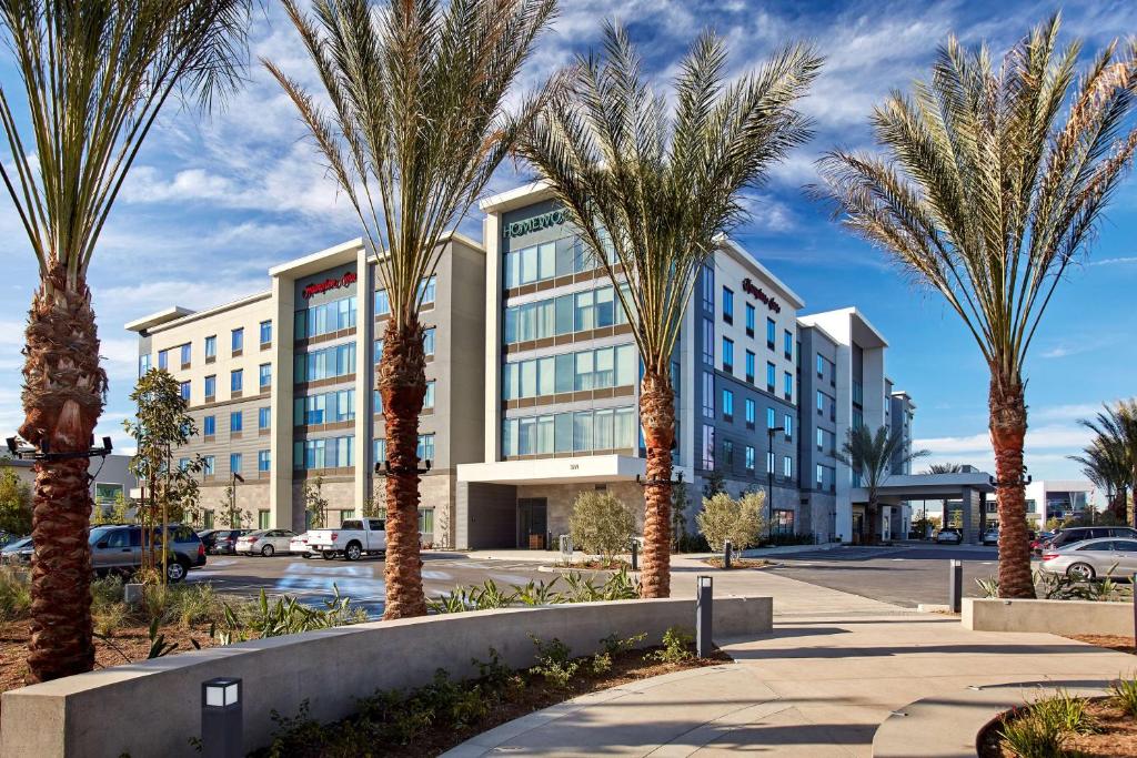 长滩加州长滩机场汉普顿酒店的一群棕榈树在一座建筑前