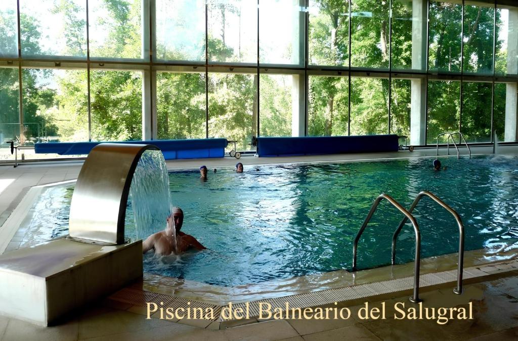 Casas del MonteCasas Rurales Acebuche, actividades familiares en entorno rural的游泳池里的人,喷泉