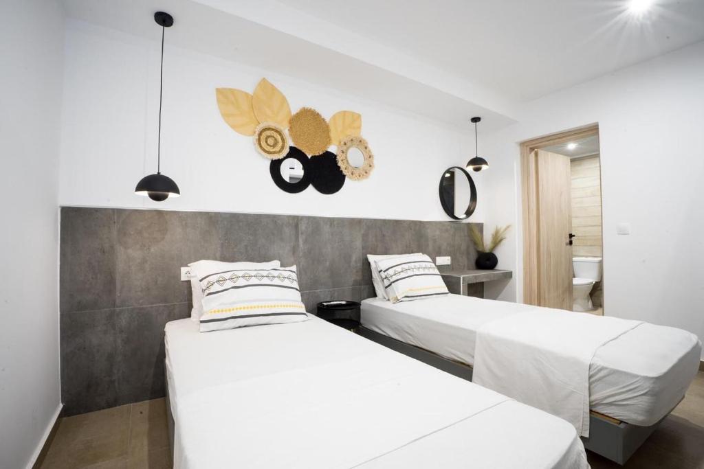 法里拉基Mousikorama Apartments的白色墙壁客房的两张床