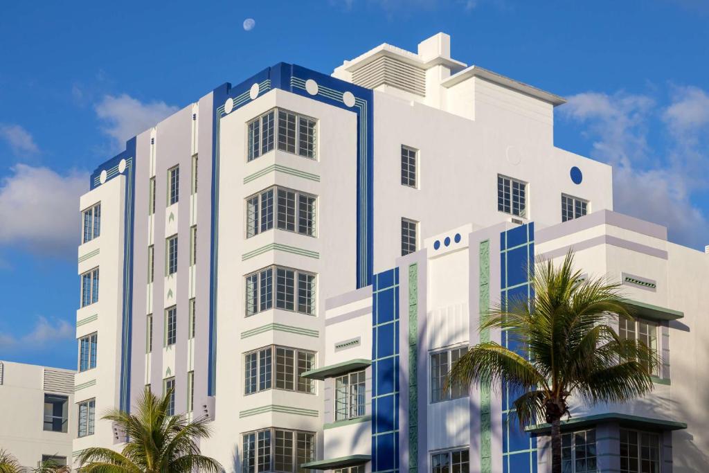 迈阿密海滩The Gabriel Miami South Beach, Curio Collection by Hilton的一座白色的大建筑,前面有棕榈树