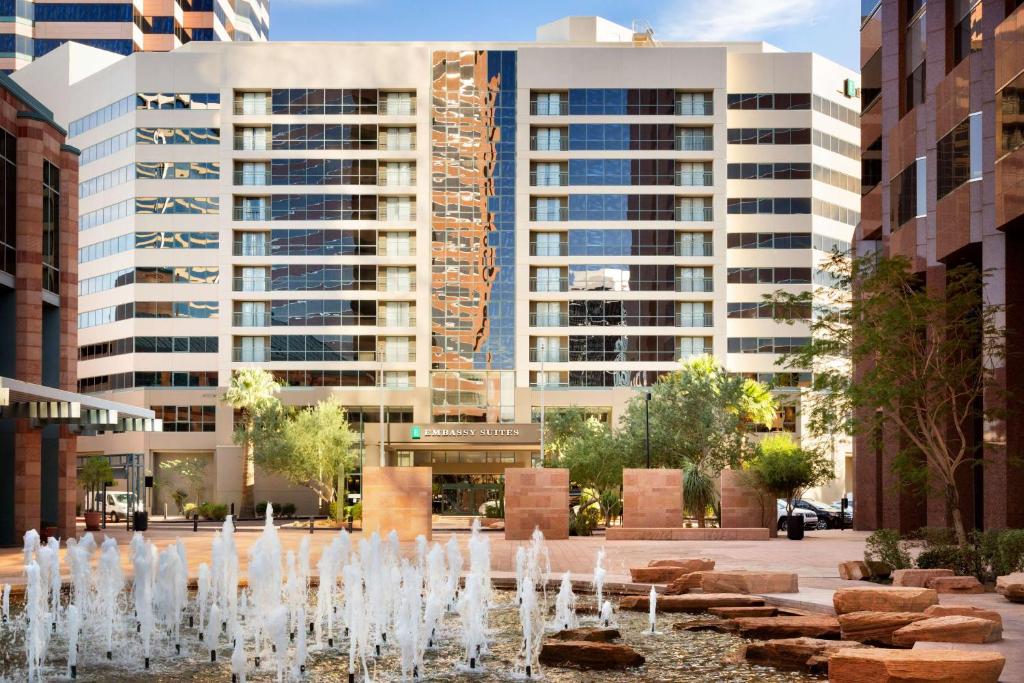 凤凰城Embassy Suites by Hilton Phoenix Downtown North的一座拥有高楼城市中心的喷泉
