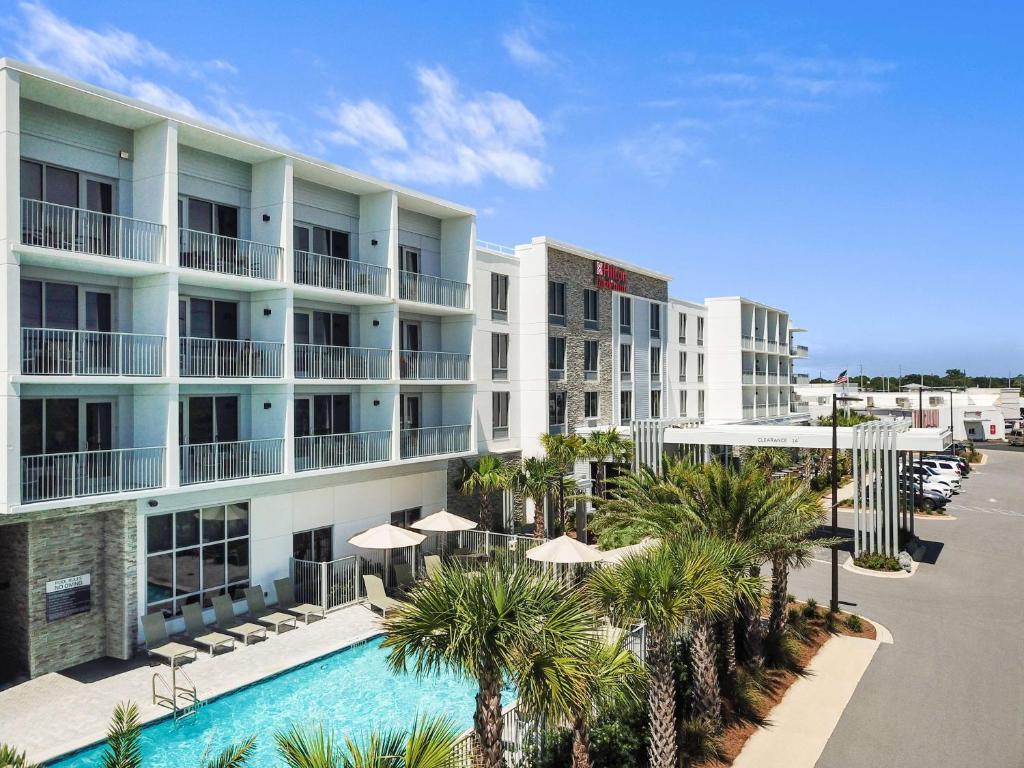 德斯坦Hilton Garden Inn Destin Miramar Beach, Fl的享有酒店空中景致,设有游泳池和棕榈树