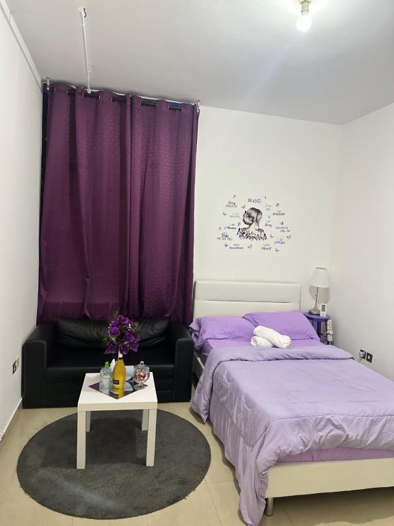 阿布扎比The Purple Place的一间卧室设有两张床和一张带紫色床单的桌子。