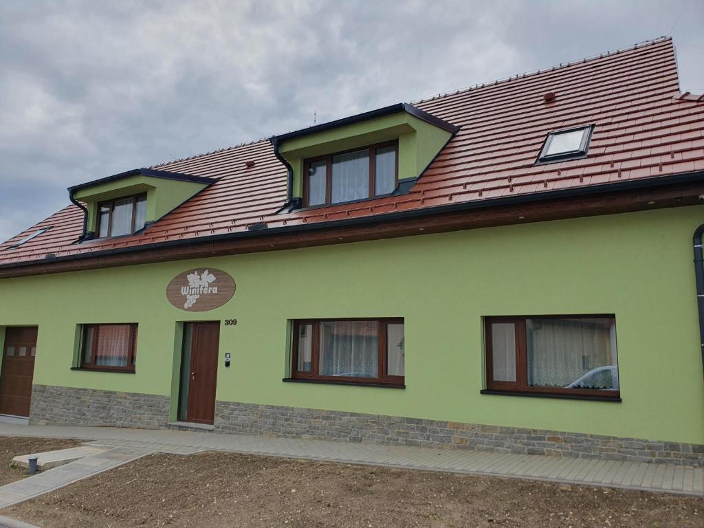 巴甫洛夫Winifera Penzion的一座带红色屋顶的绿色房子