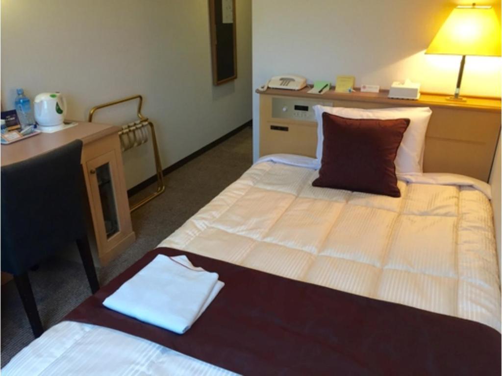 佐世保Sunwest Hotel Sasebo - Vacation STAY 22075v的酒店客房配有两张床和一张书桌
