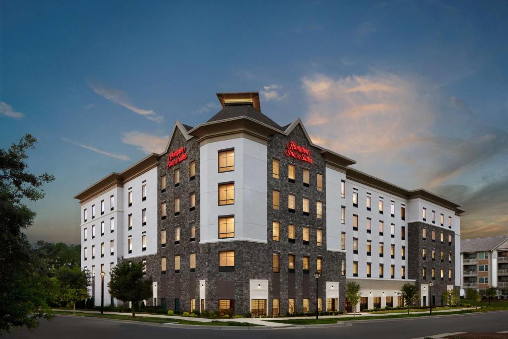 夏洛特Hampton Inn & Suites Charlotte Steele Creek Road, NC的一座白色的大建筑,上面有红色的标志