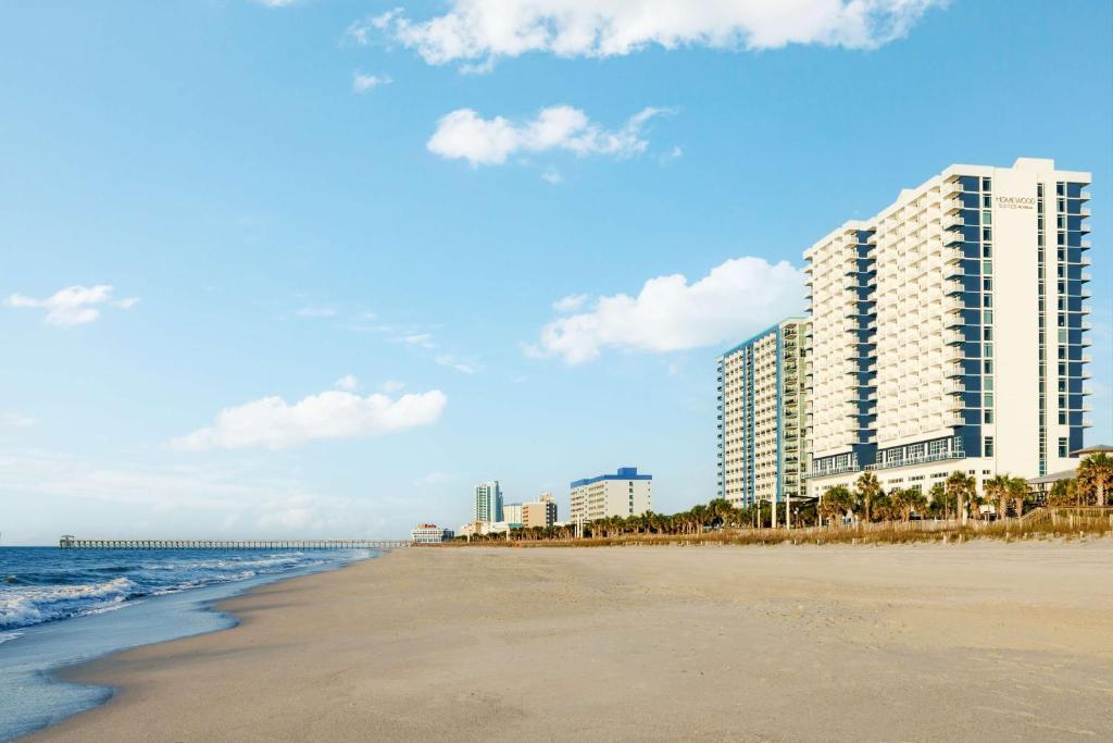 默特尔比奇Homewood Suites by Hilton Myrtle Beach Oceanfront的享有海滩、建筑和大海的景色