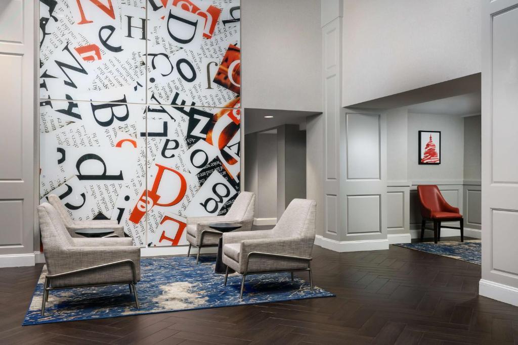 华盛顿Hampton Inn Washington DC White House的一间设有椅子的等候室,墙上挂着字母
