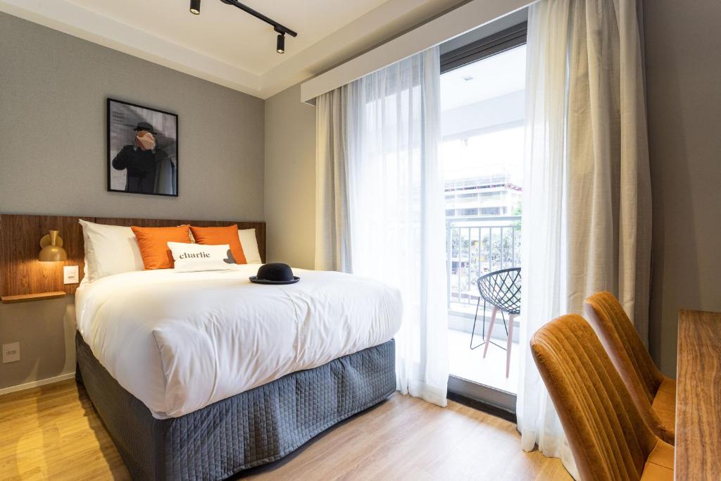 圣保罗Charlie Hotel Atmosfera Paulista的一间卧室设有一张床和一个大窗户