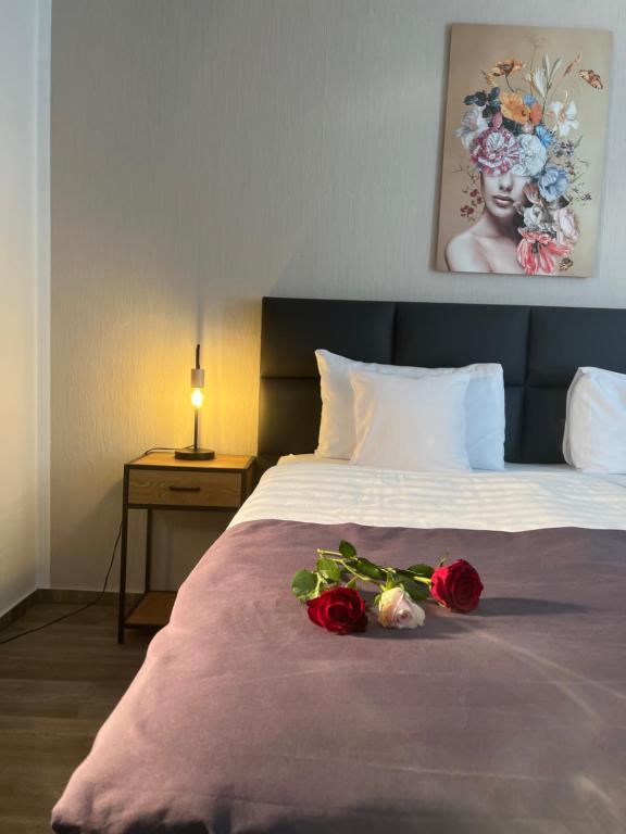 文登Hotel Restaurant Zum Landmann的一间卧室,床上有两朵玫瑰
